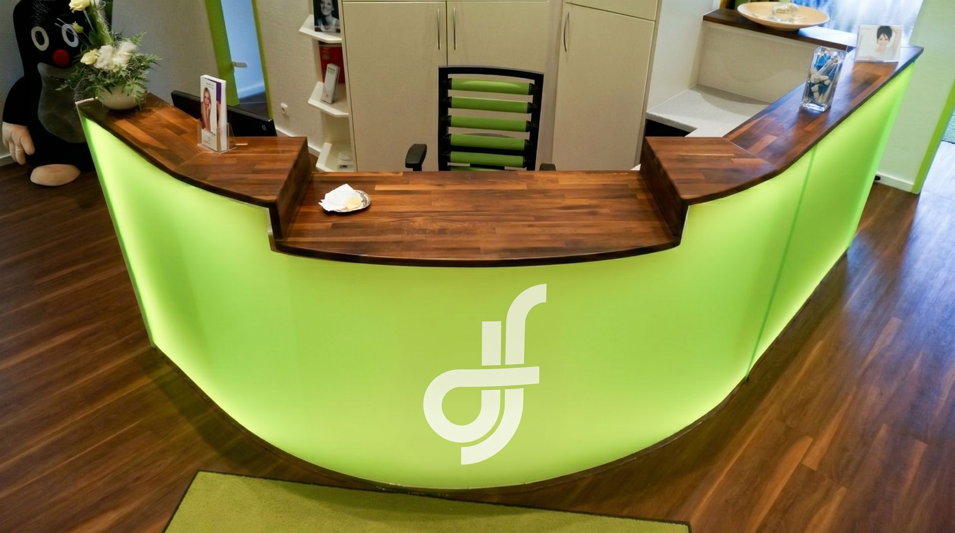 Reception of the Zahnspruchsvoll practice with its green-lit front desk